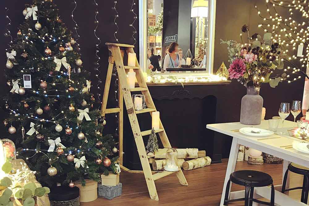 Sapin de noël décoré et escabeau en bois avec objets de noël.