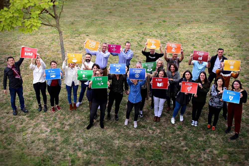 Photo de groupe brandissant des cartes sur le thème de la RSE