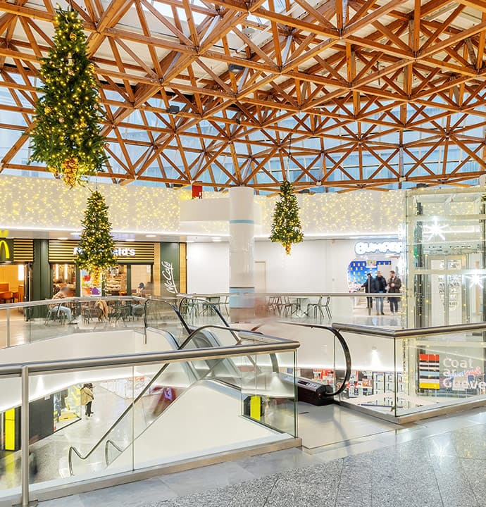 Décoration d'un centre commercial avec des sapins lumineux suspendus