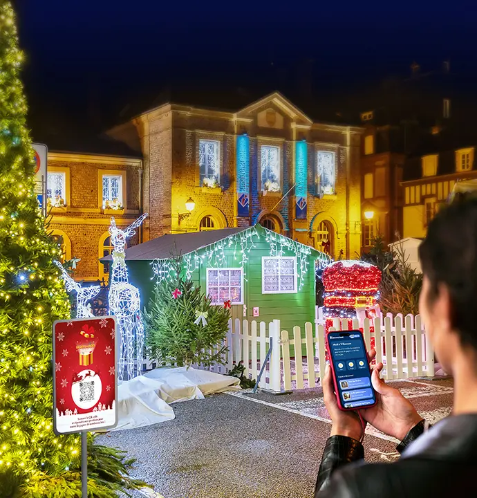 Femme portable à la main qui joue au défi de noël devant des décorations