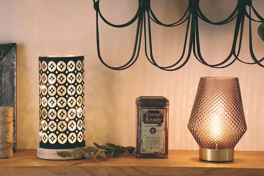 Vase et lampe posés sur une étagère en bois