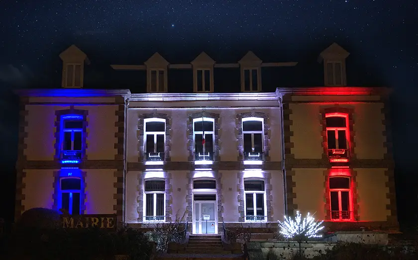 Projecteur LED projetant les couleurs bleu blanc et rouge sur une mairie